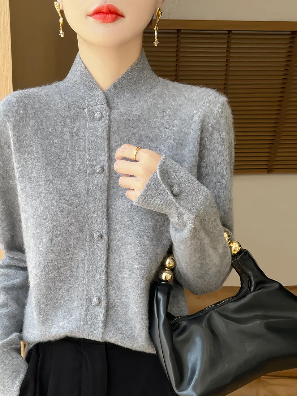 Cardigan d'hiver en laine pour femme Femme portant un cardigan gris à col haut et tenant un sac à main noir.