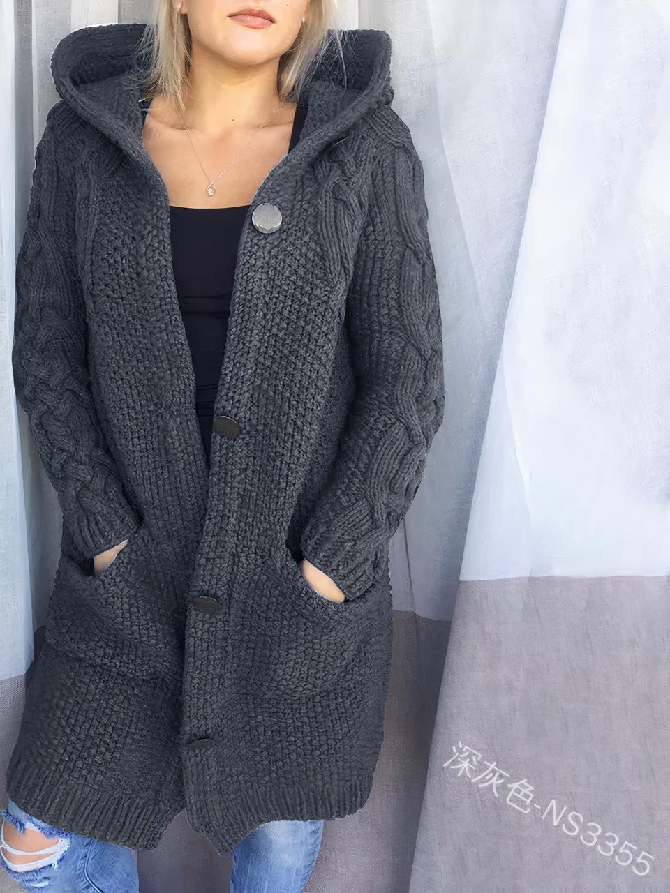 Une femme porte un jean, un top noir et un cardigan mi long gris foncé