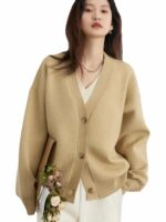Femme portant un gilet cardigan beige sur fond blanc.