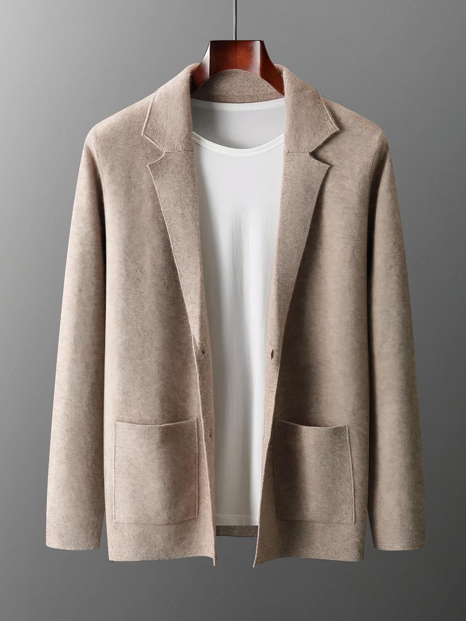 Photo d'une veste cardigan marron clair pour homme à col et poches plaquées sur un top blanc le tout sur un cintre marron foncé, photo prise sur un fond gris clair à gauche et foncé à droite