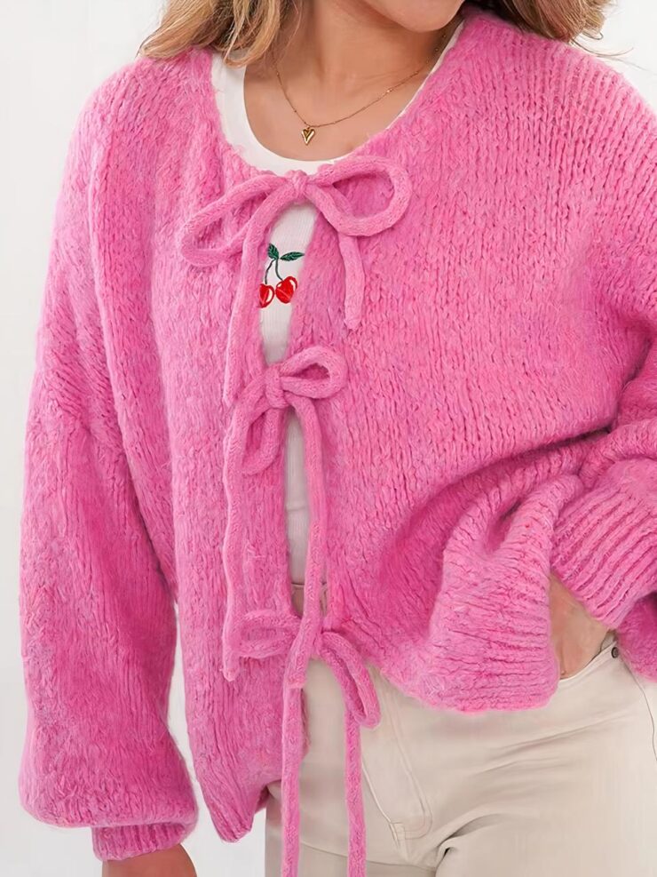 femme brune cheveux longs rose col rond avec lacets.