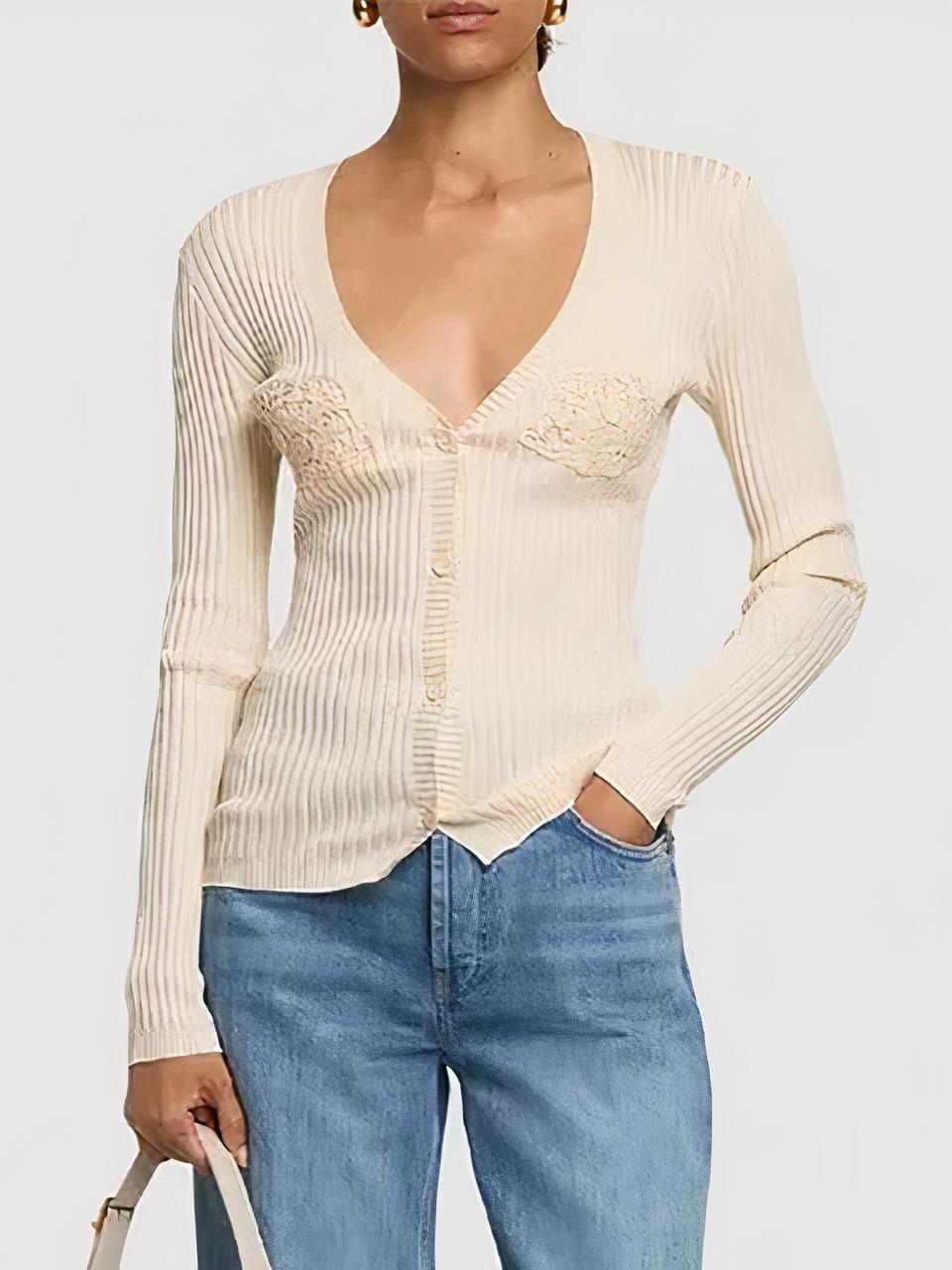 Femme portant un cardigan beige et un jean bleu sur fond gris.