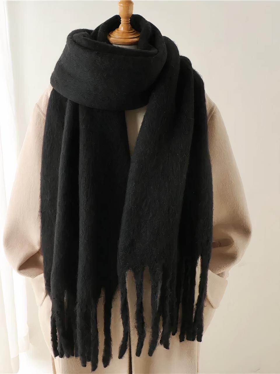 Echarpe noir longue et épaisse enroulé autour d'un mannequin sur un manteau beige.
